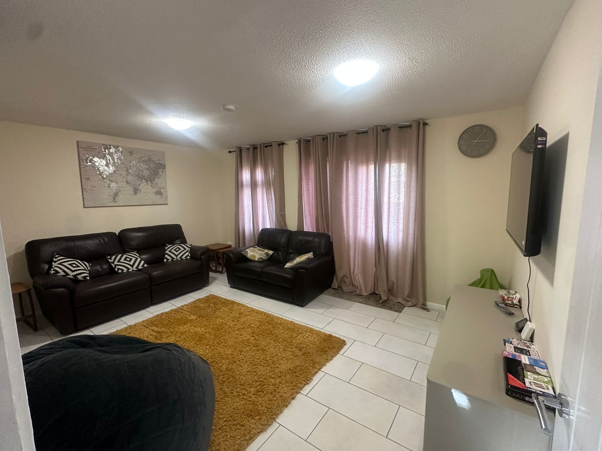 Gannett House living room with comfortable sofas and world map wall art